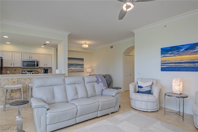 living area featuring visible vents, arched walkways, ceiling fan, crown molding, and light tile patterned flooring