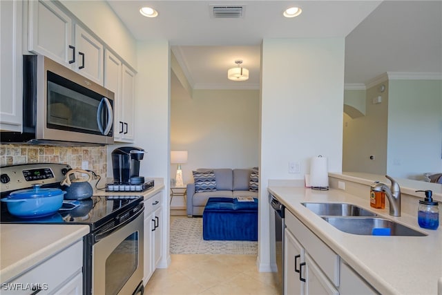 kitchen with stainless steel appliances, light countertops, visible vents, white cabinets, and a sink