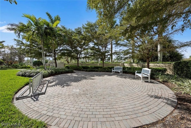 view of property's community featuring a yard, a patio area, and fence