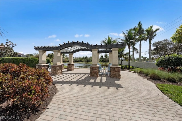 view of home's community with fence and a pergola