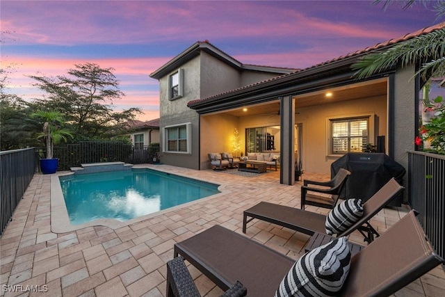 back of property at dusk with a fenced backyard, a fenced in pool, a patio, an outdoor hangout area, and stucco siding