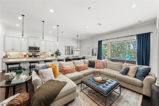 living area featuring a notable chandelier, wood finished floors, visible vents, and recessed lighting