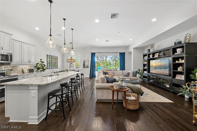 living room with a chandelier, recessed lighting, visible vents, and dark wood finished floors