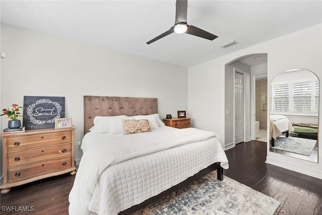 bedroom featuring arched walkways, visible vents, dark wood-type flooring, ceiling fan, and baseboards