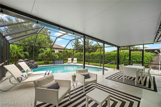 outdoor pool featuring glass enclosure, a patio, and an outdoor hangout area