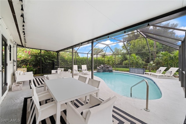 pool featuring a patio area, glass enclosure, and outdoor dining area