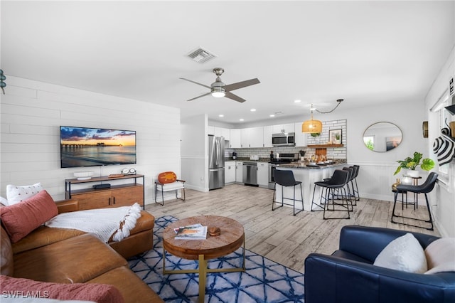 living room with light wood-style floors, recessed lighting, visible vents, and ceiling fan