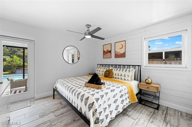 bedroom with baseboards, ceiling fan, light wood finished floors, and access to exterior