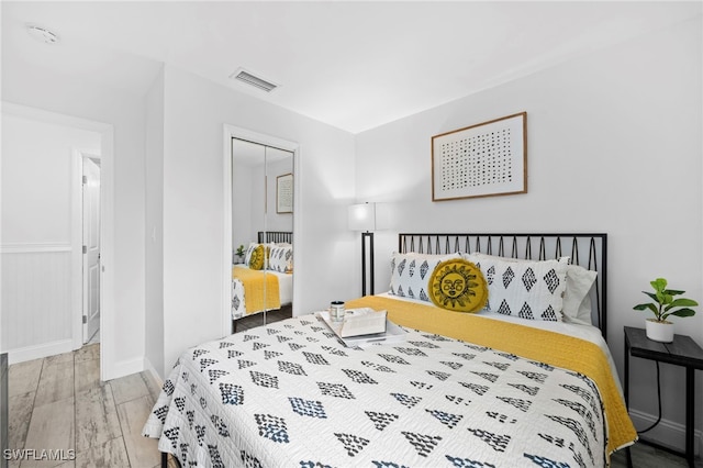 bedroom featuring a closet, visible vents, and wood finished floors