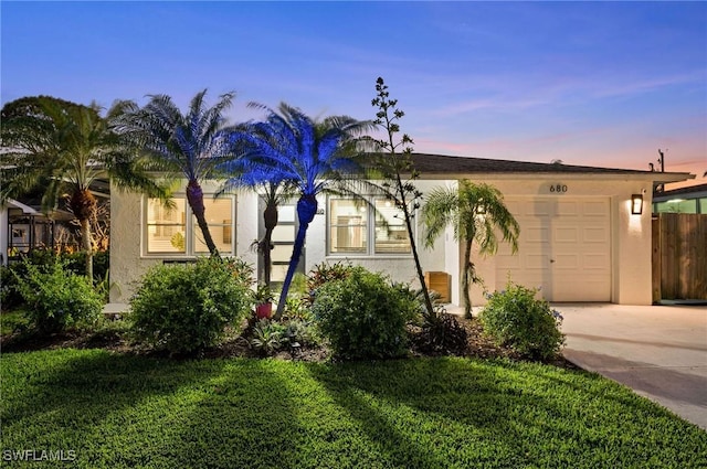 view of front of property featuring a garage, driveway, and stucco siding