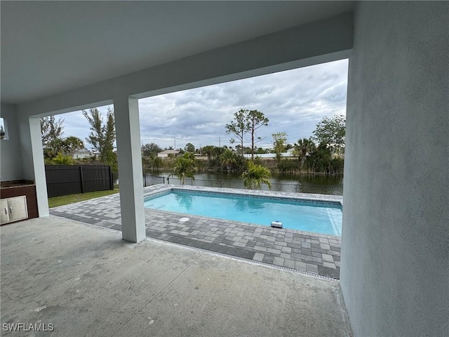 view of pool featuring a patio and a water view