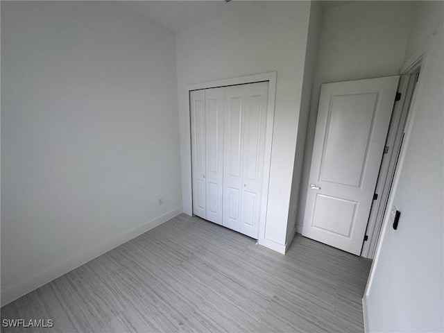 unfurnished bedroom with a closet and light hardwood / wood-style floors