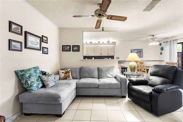 living area with light tile patterned floors, a textured ceiling, visible vents, and a ceiling fan