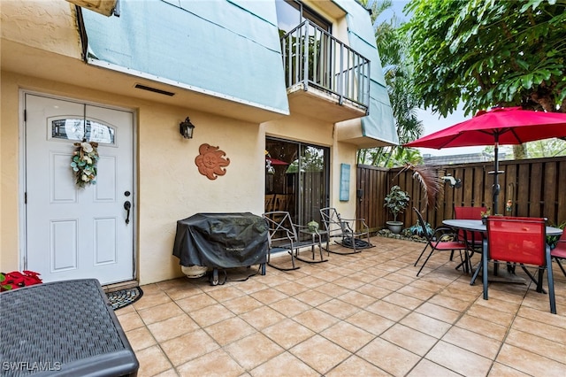 view of patio with outdoor dining area, fence, and grilling area