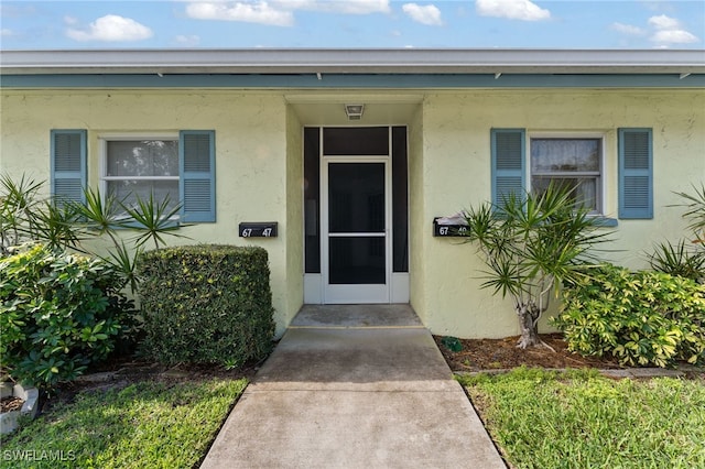 entrance to property with stucco siding