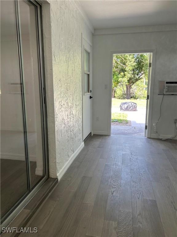 interior space featuring an AC wall unit and dark wood-type flooring