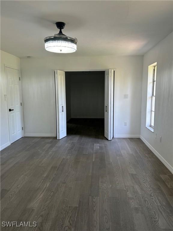 unfurnished dining area with dark wood-type flooring