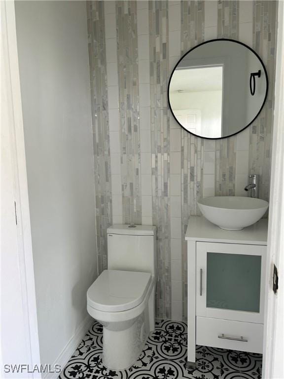 bathroom featuring tile patterned floors, toilet, tile walls, and vanity