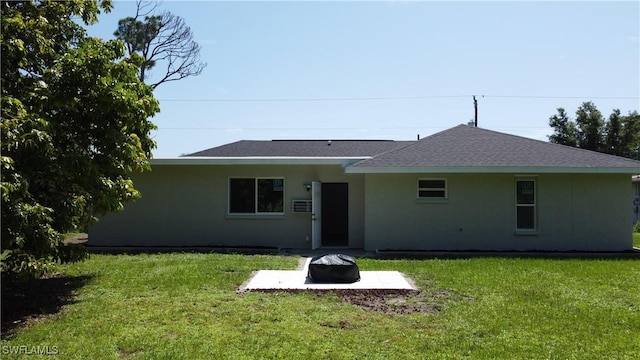 rear view of property featuring a lawn