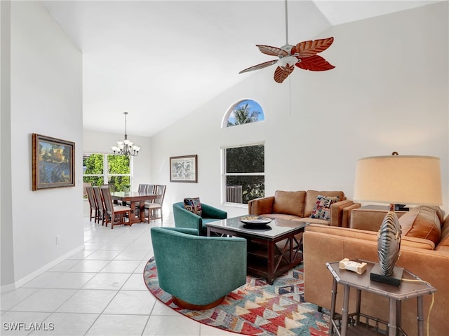 living room featuring light tile patterned floors, high vaulted ceiling, ceiling fan with notable chandelier, and baseboards