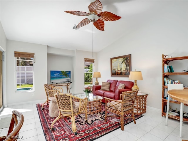 living area featuring light tile patterned floors, visible vents, baseboards, ceiling fan, and vaulted ceiling