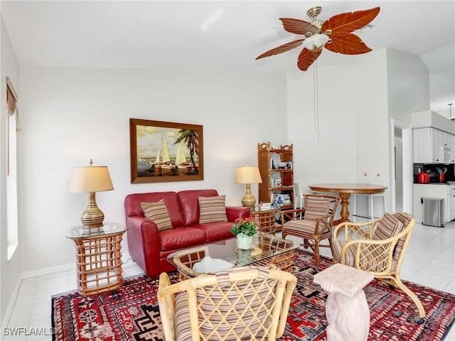 living room featuring light tile patterned floors, vaulted ceiling, a ceiling fan, and baseboards