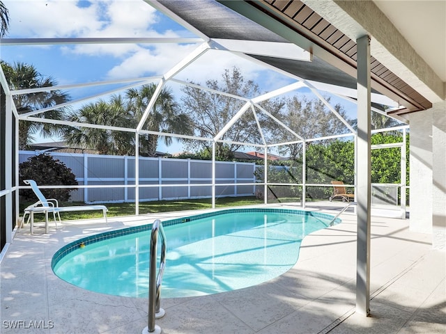 view of pool featuring glass enclosure, a patio, a fenced backyard, and a fenced in pool