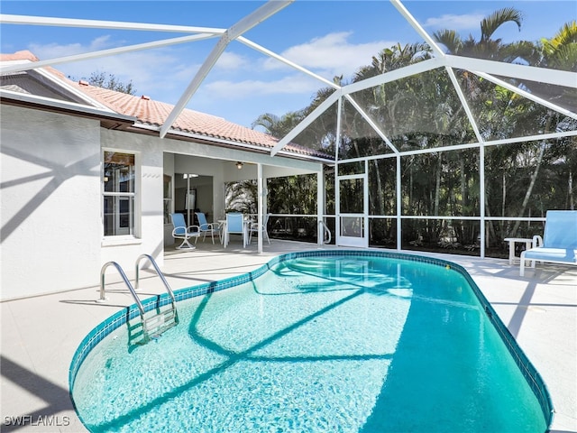 pool featuring glass enclosure and a patio