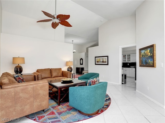 living room with baseboards, high vaulted ceiling, a ceiling fan, and light tile patterned flooring