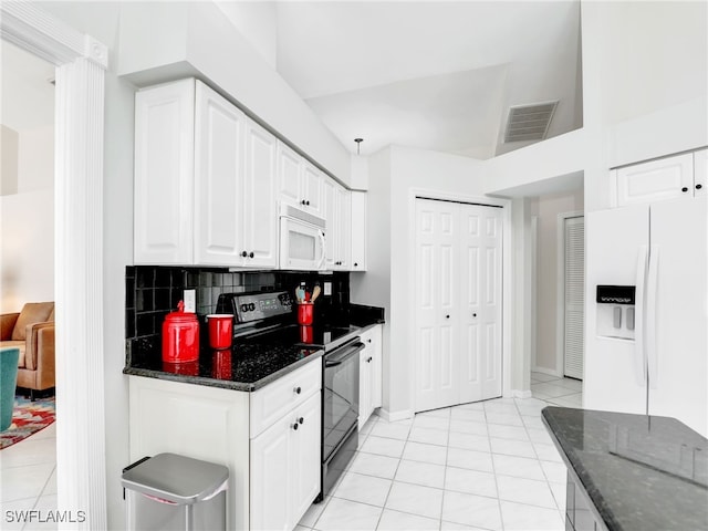 kitchen with light tile patterned floors, white appliances, visible vents, white cabinets, and dark stone countertops