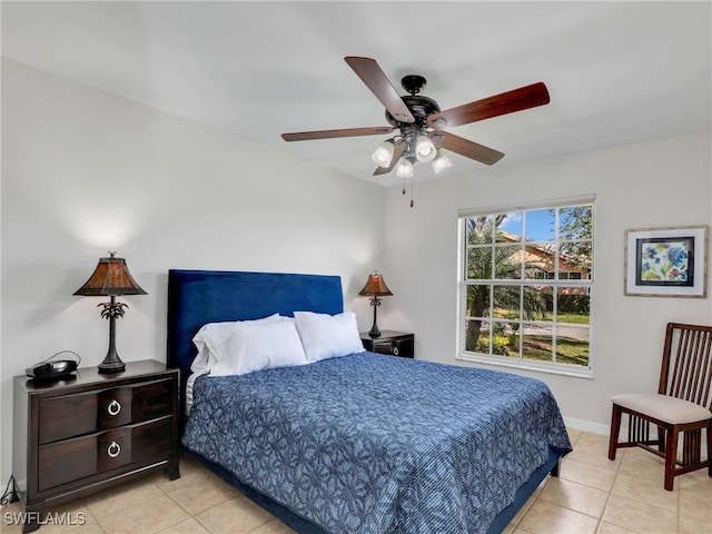 bedroom featuring a ceiling fan, light tile patterned flooring, and baseboards