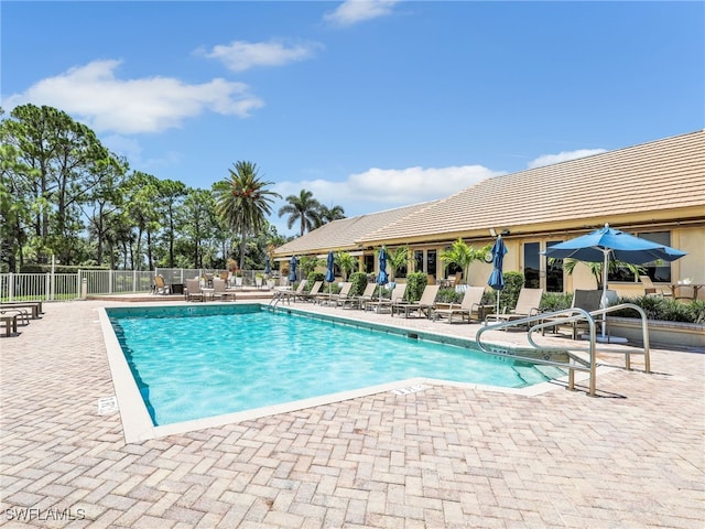 community pool with fence and a patio