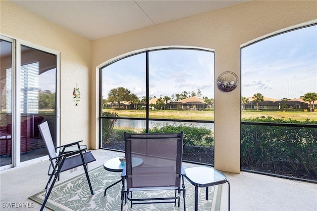 sunroom / solarium featuring a water view