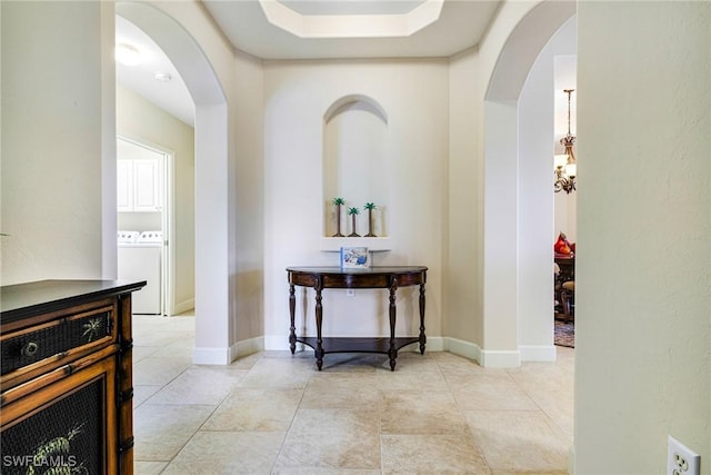 10644 Pelican Preserve Blvd Unit 102, Fort Myers, FL 33913 - hall featuring arched walkways, washing machine and dryer, and light tile patterned floors