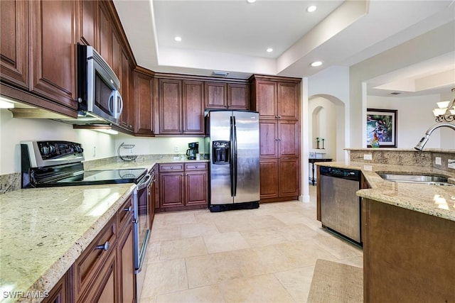 10644 Pelican Preserve Blvd Unit 102, Fort Myers, FL 33913 - kitchen with stainless steel appliances, a sink, arched walkways, a tray ceiling, and recessed lighting