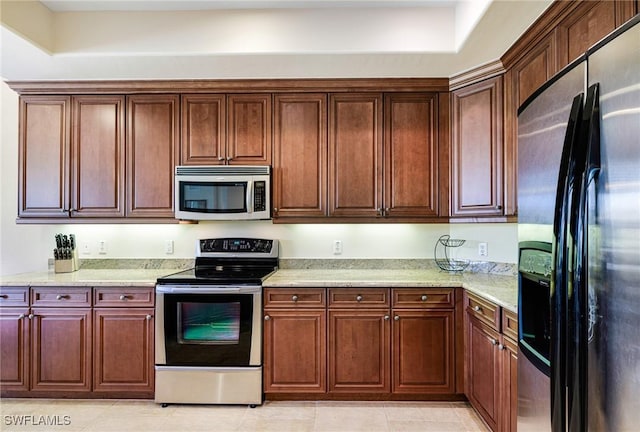10644 Pelican Preserve Blvd Unit 102, Fort Myers, FL 33913 - kitchen featuring appliances with stainless steel finishes, light stone counters, and light tile patterned flooring