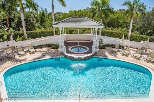 pool featuring a hot tub, fence, and a gazebo