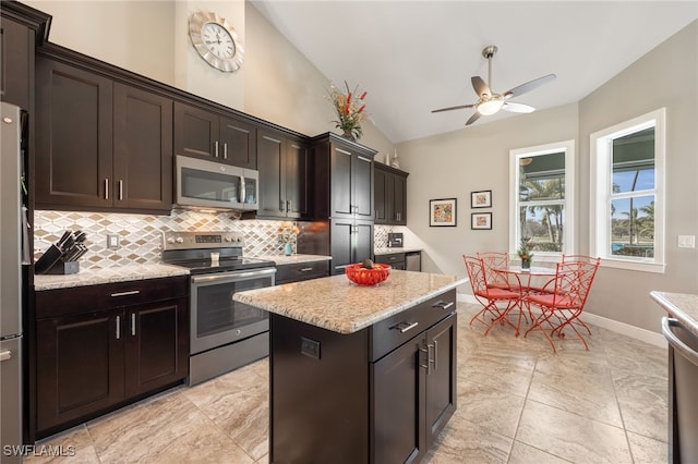 kitchen featuring dark brown cabinetry, stainless steel appliances, decorative backsplash, and a center island