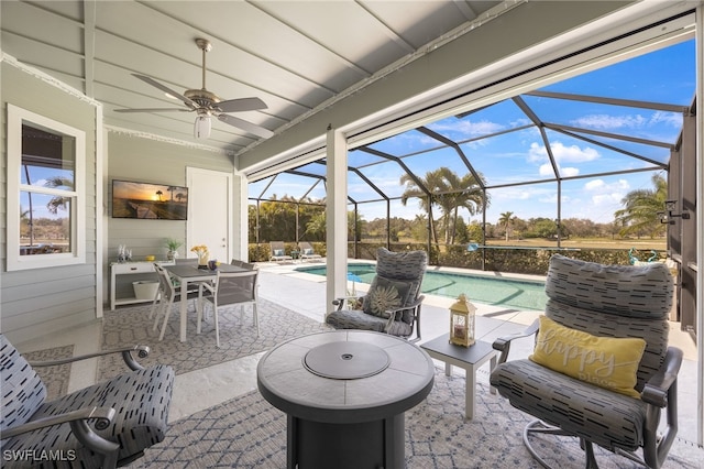 view of patio / terrace featuring glass enclosure, an outdoor pool, a ceiling fan, and outdoor dining space