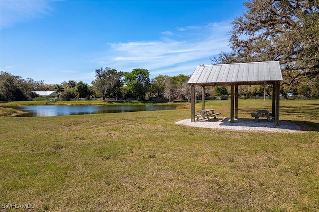 surrounding community featuring a gazebo, a lawn, and a water view