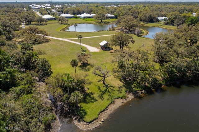 birds eye view of property with a water view and a wooded view