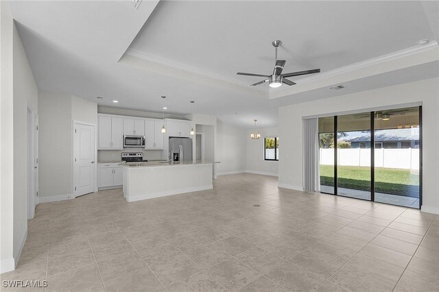 1729 SW 22nd Ter, Cape Coral, FL 33991 - unfurnished living room with a tray ceiling, light tile patterned floors, and ceiling fan with notable chandelier