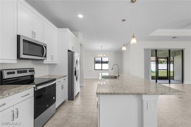 1729 SW 22nd Ter, Cape Coral, FL 33991 - kitchen with stainless steel appliances, an island with sink, white cabinets, and hanging light fixtures