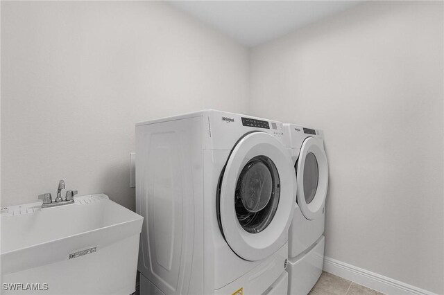 1729 SW 22nd Ter, Cape Coral, FL 33991 - washroom with light tile patterned flooring, washer and clothes dryer, and sink