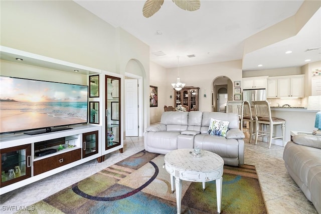 living room featuring arched walkways, ceiling fan, light tile patterned floors, and visible vents