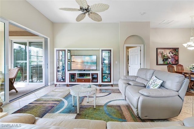 living area with light tile patterned floors, ceiling fan with notable chandelier, visible vents, and baseboards