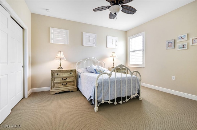 carpeted bedroom with a ceiling fan, a closet, and baseboards