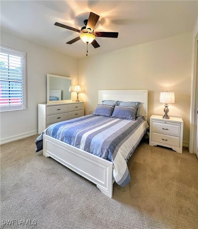 bedroom featuring light carpet, ceiling fan, and baseboards