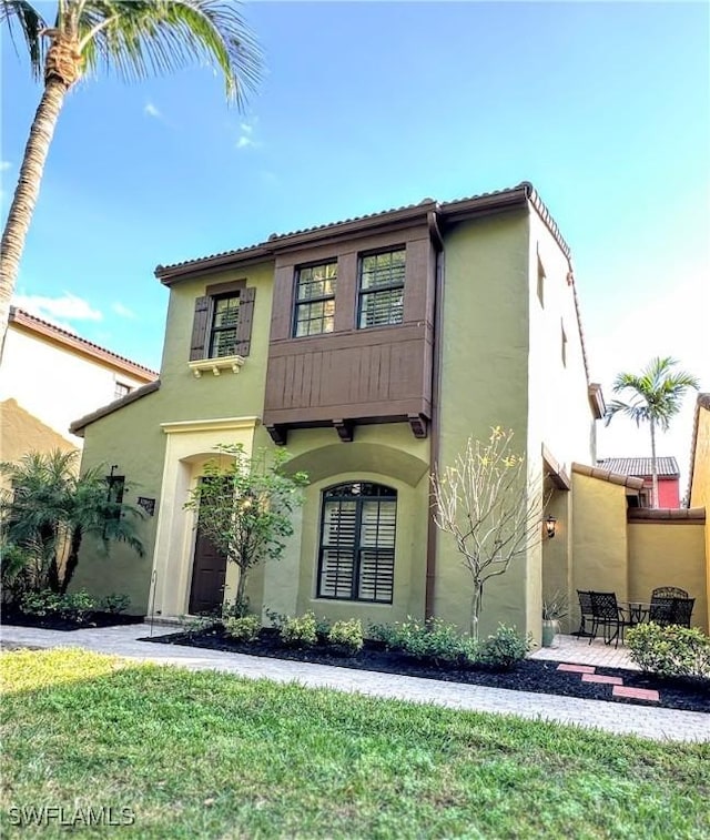 mediterranean / spanish-style home featuring a front yard and stucco siding