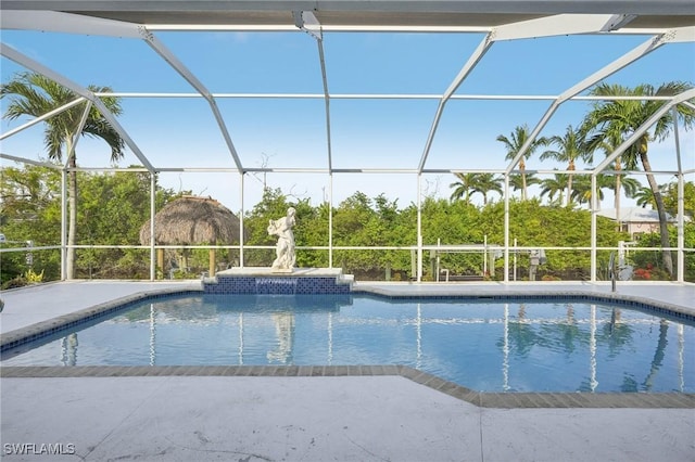 view of swimming pool with glass enclosure and a patio